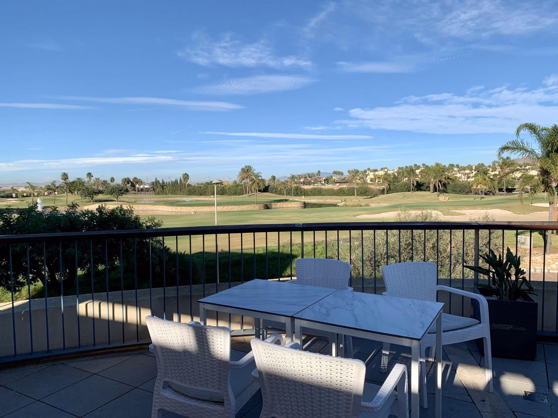 Sun-drenched terrace with modern dining set overlooking manicured golf course at spacious 3-bedroom bungalow in Roda Golf, San Javier