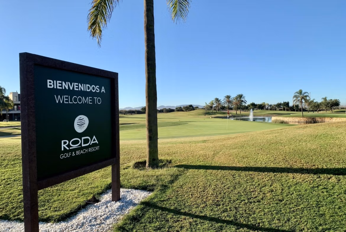 Sunlit, manicured golf course with palm trees and fountain at Roda Golf in San Javier, ideal view for a spacious bungalow.