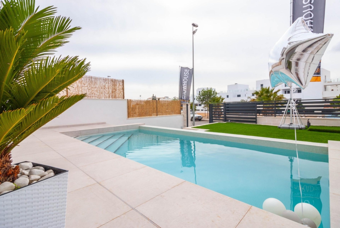 Private modern pool with sleek tiled terrace and landscaped greenery at luxury 3-bedroom villa in Villamartin, Orihuela Costa