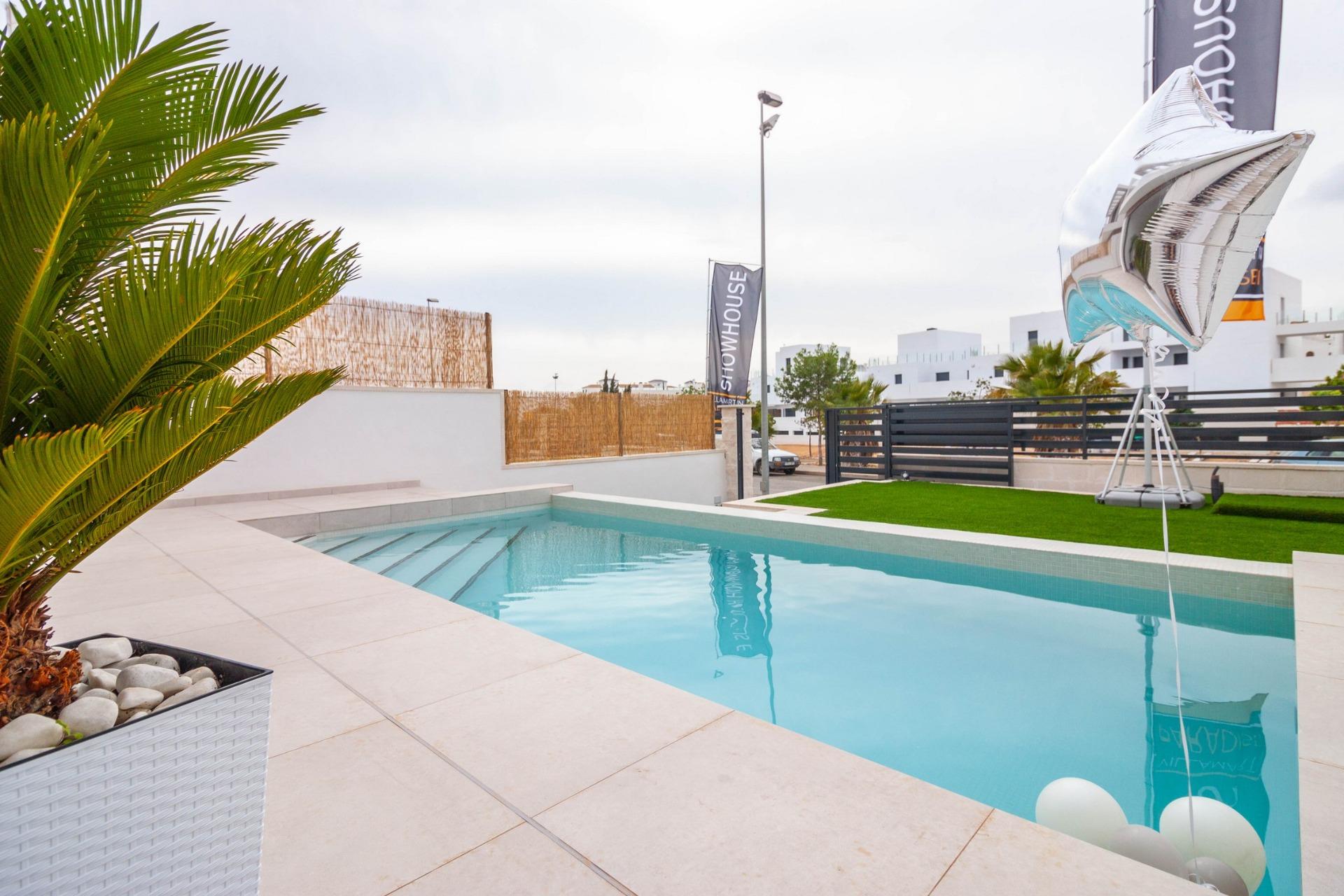 Private modern pool with sleek tiled terrace and landscaped greenery at luxury 3-bedroom villa in Villamartin, Orihuela Costa