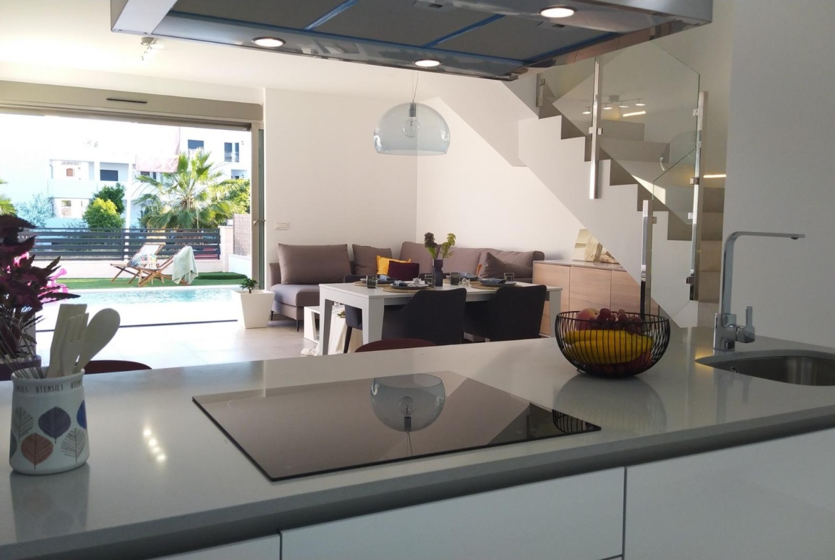 Bright modern kitchen with sleek island and open-plan living area in a 3-bedroom villa with private pool in Villamartin, Orihuela Costa.