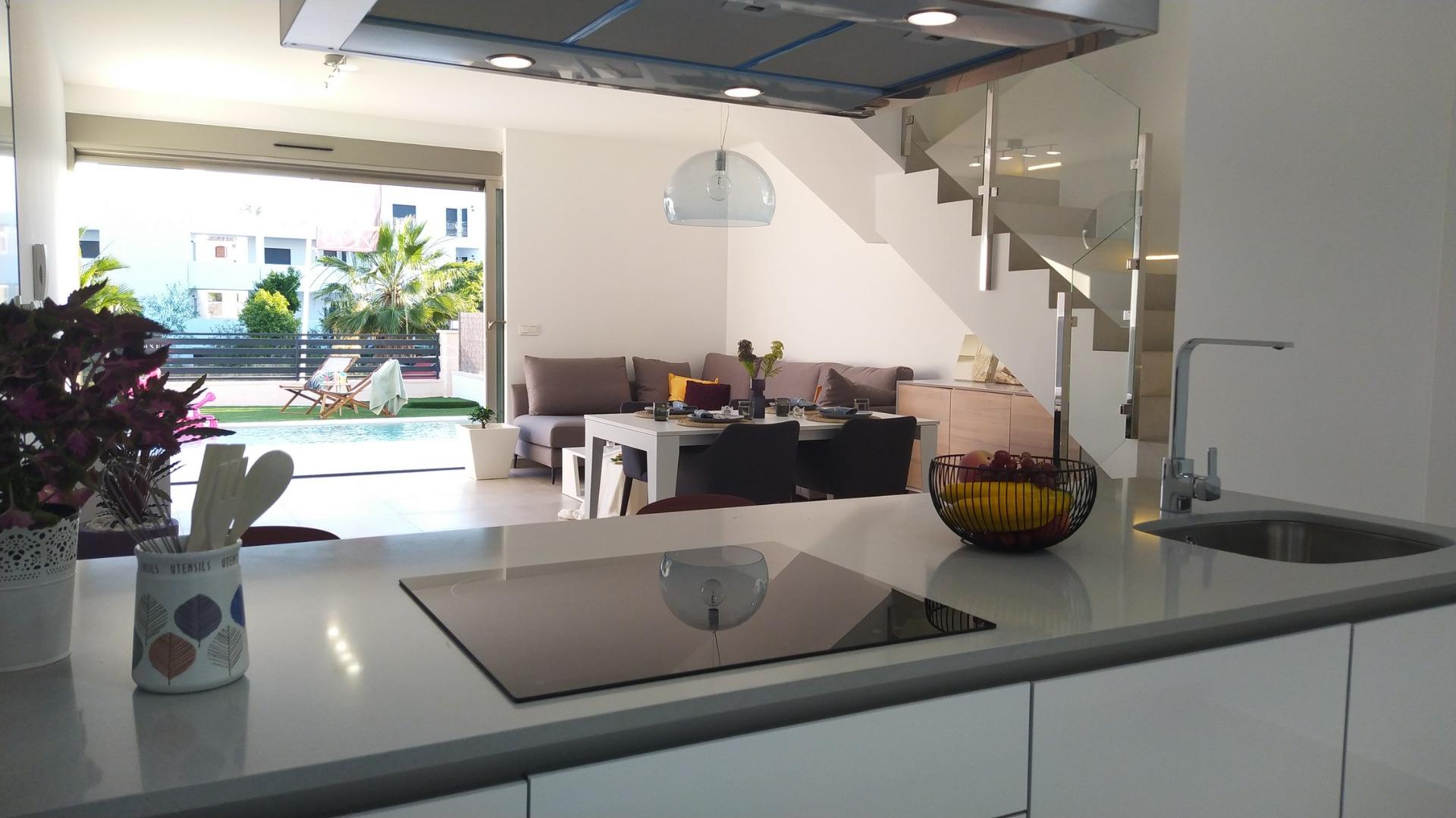Bright modern kitchen with sleek island and open-plan living area in a 3-bedroom villa with private pool in Villamartin, Orihuela Costa.