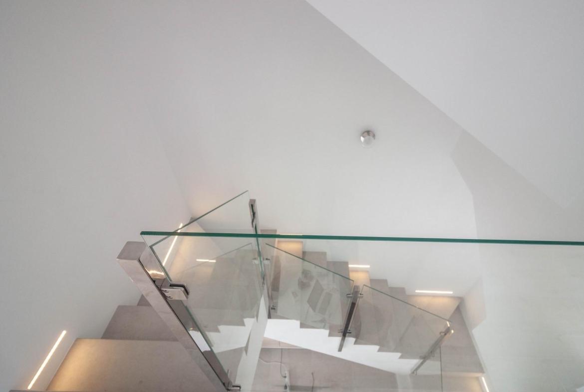 Bright, modern staircase with sleek glass balustrade in luxury new build 3-bedroom villa in Villamartin, Orihuela Costa