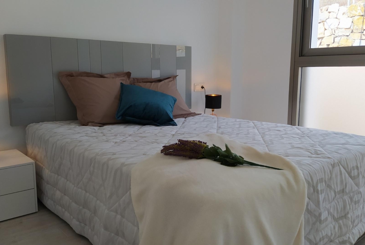 Bright modern bedroom with soft linens and bedside lamps in a new 3-bedroom villa in Villamartin, Orihuela Costa.