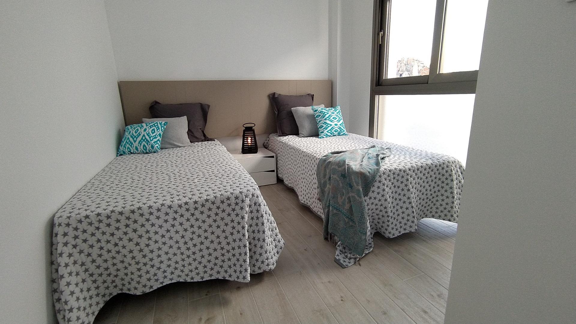Bright modern twin bedroom with large window and minimalist decor in a 3-bedroom villa in Villamartin, Orihuela Costa.