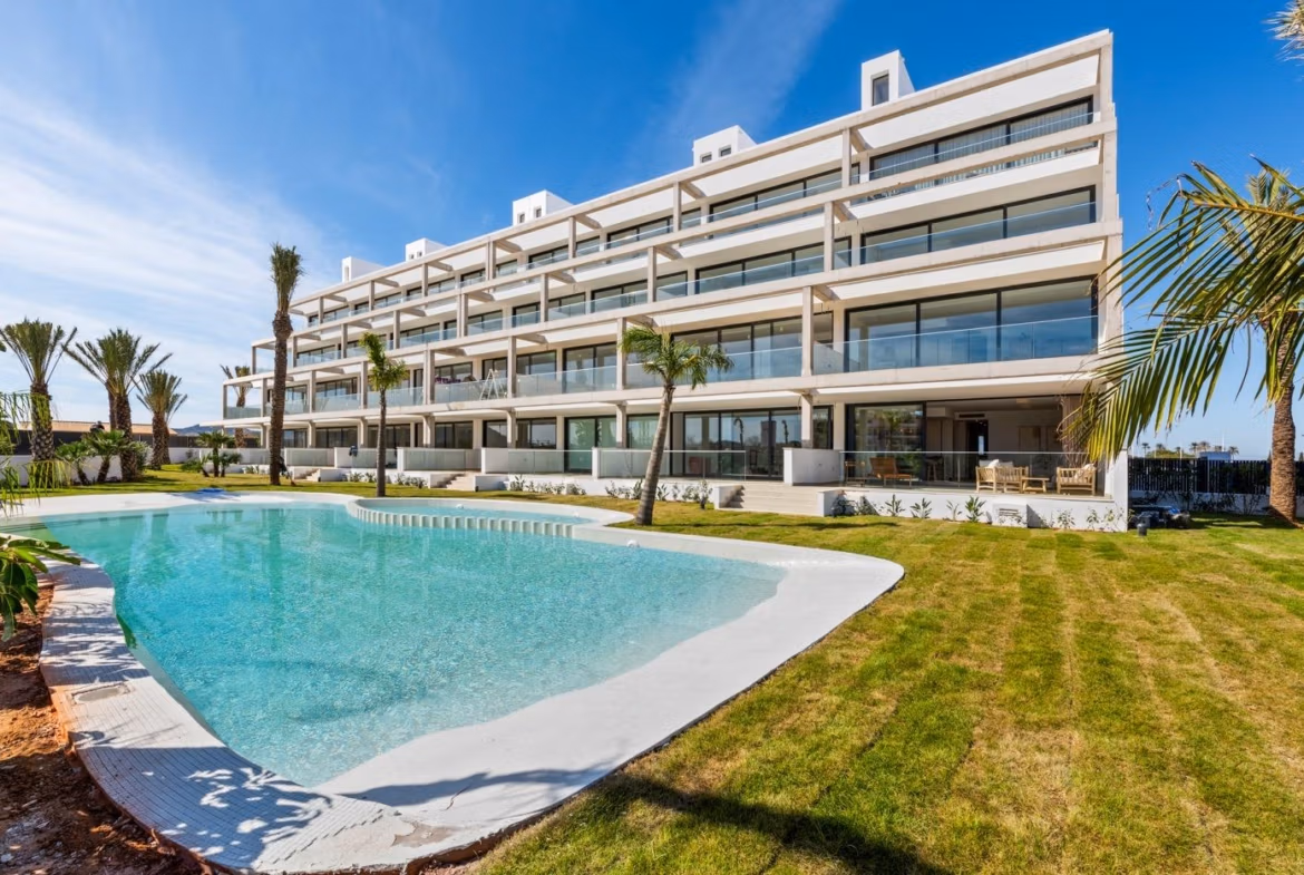 Modern elevated 2-bedroom penthouse in Mar de Cristal with spacious private terrace overlooking a pristine pool and lush gardens.