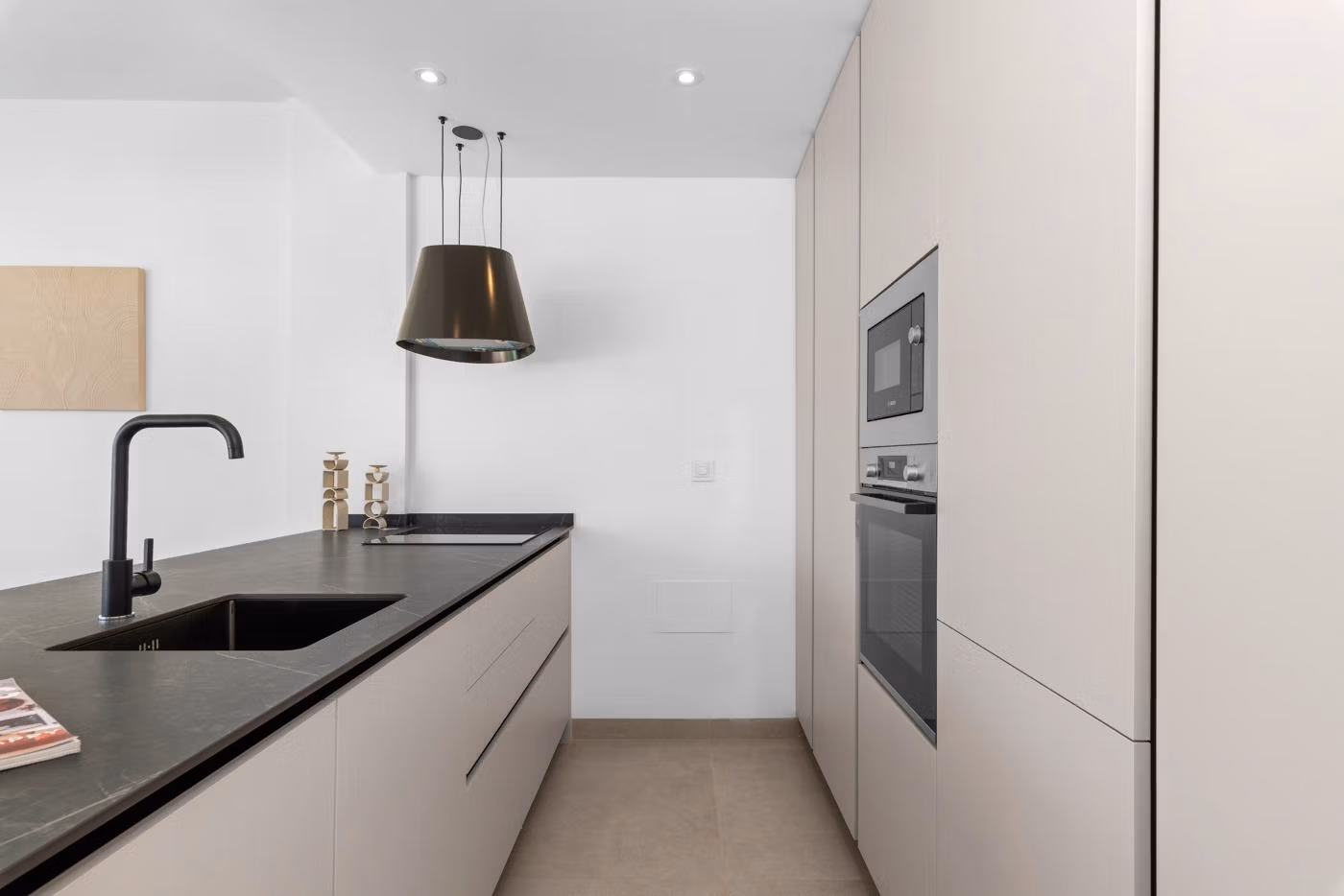 Sleek modern kitchen with matte cabinetry and black fixtures in elevated 2 bedroom penthouse with private solarium in Mar de Cristal