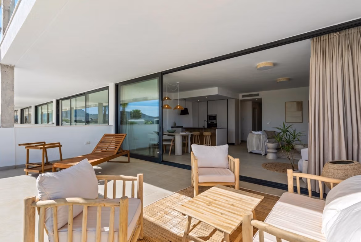 Sun-drenched elevated terrace with modern wooden seating overlooking sleek open-plan living in a 2-bedroom penthouse in Mar de Cristal.
