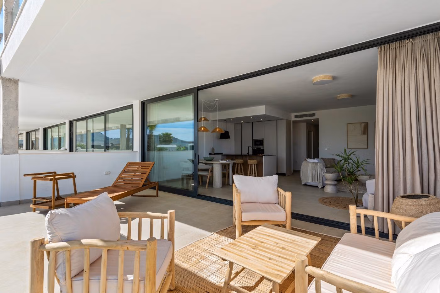Sun-drenched elevated terrace with modern wooden seating overlooking sleek open-plan living in a 2-bedroom penthouse in Mar de Cristal.