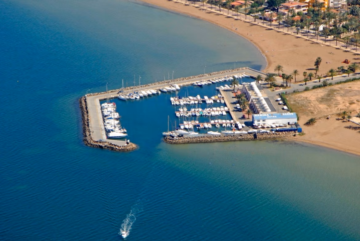 Panoramic coastal view of Mar de Cristal with a modern marina and sandy beach near the elevated 2-bedroom penthouse with private solarium.