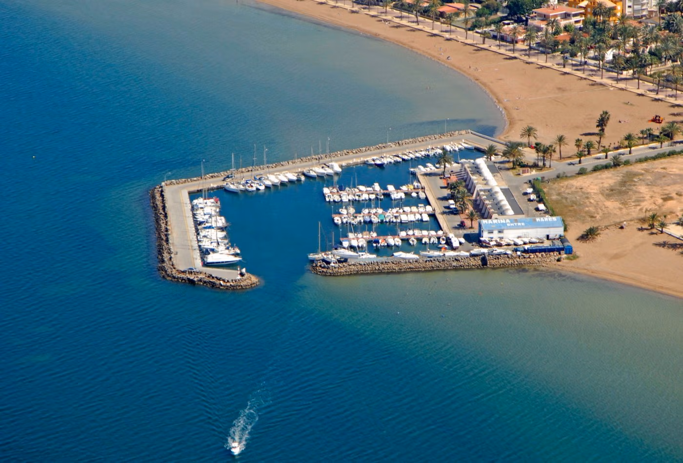 Panoramic coastal view of Mar de Cristal with a modern marina and sandy beach near the elevated 2-bedroom penthouse with private solarium.