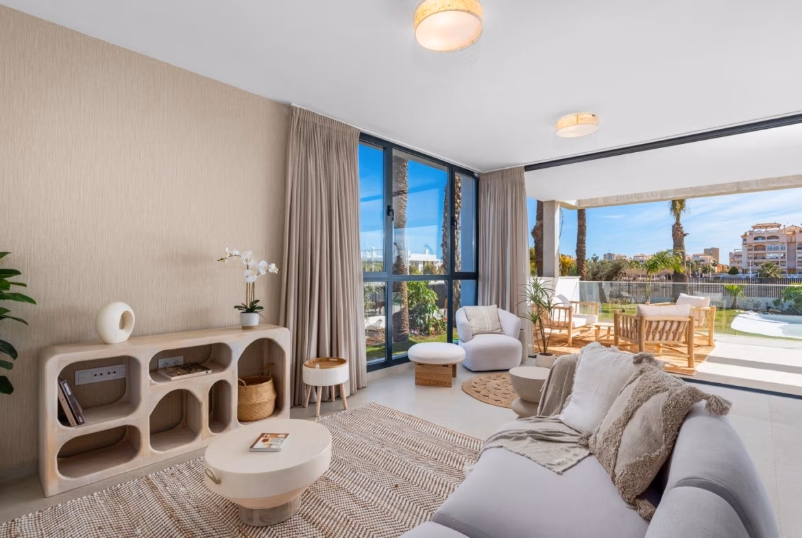 Bright and elegant living area with modern furnishings and large windows leading to a sun-drenched terrace in Mar de Cristal penthouse