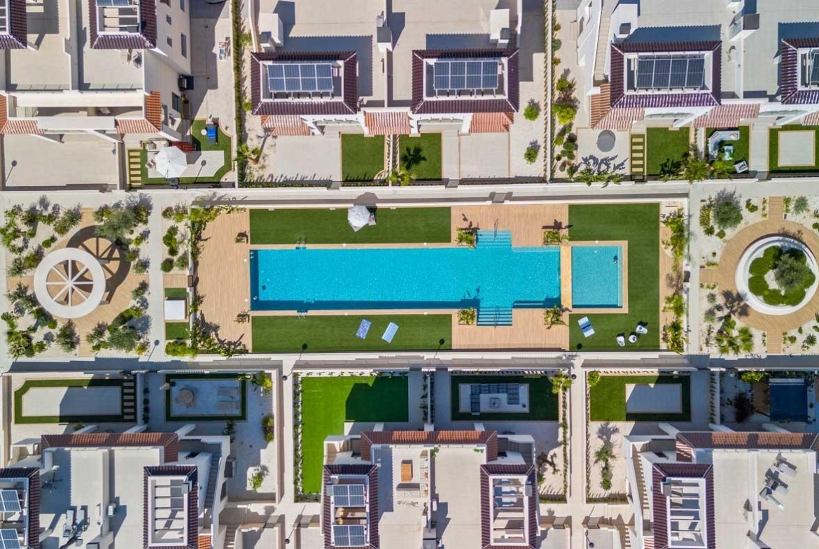Aerial view of a modern new build 2-bedroom ground floor bungalow in Doña Pepa, Rojales with a spacious pool and landscaped gardens.