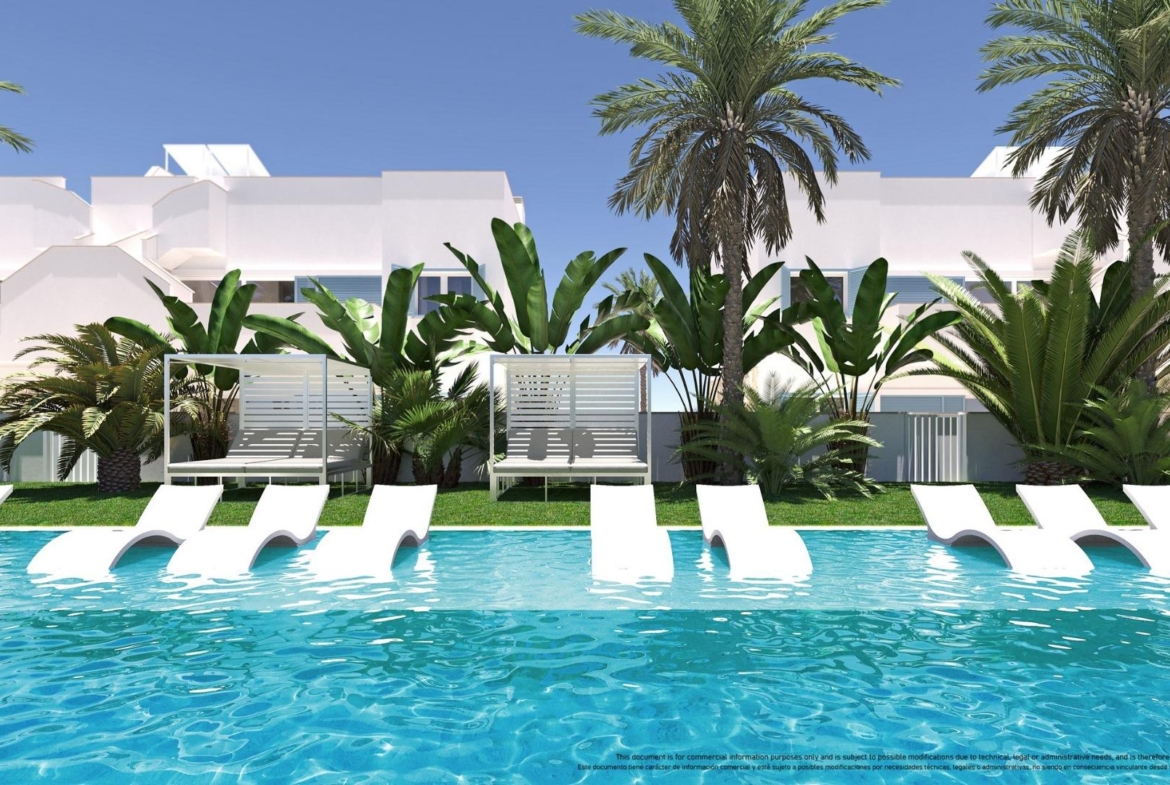 NEW-BUILD-RESIDENTIAL-COMPLEX-IN-TORRE-DE-LA-HORADADA-13 Sun-drenched pool with sleek loungers and lush tropical greenery in front of modern top floor 3-bedroom apartment in Torre de la Horadada.