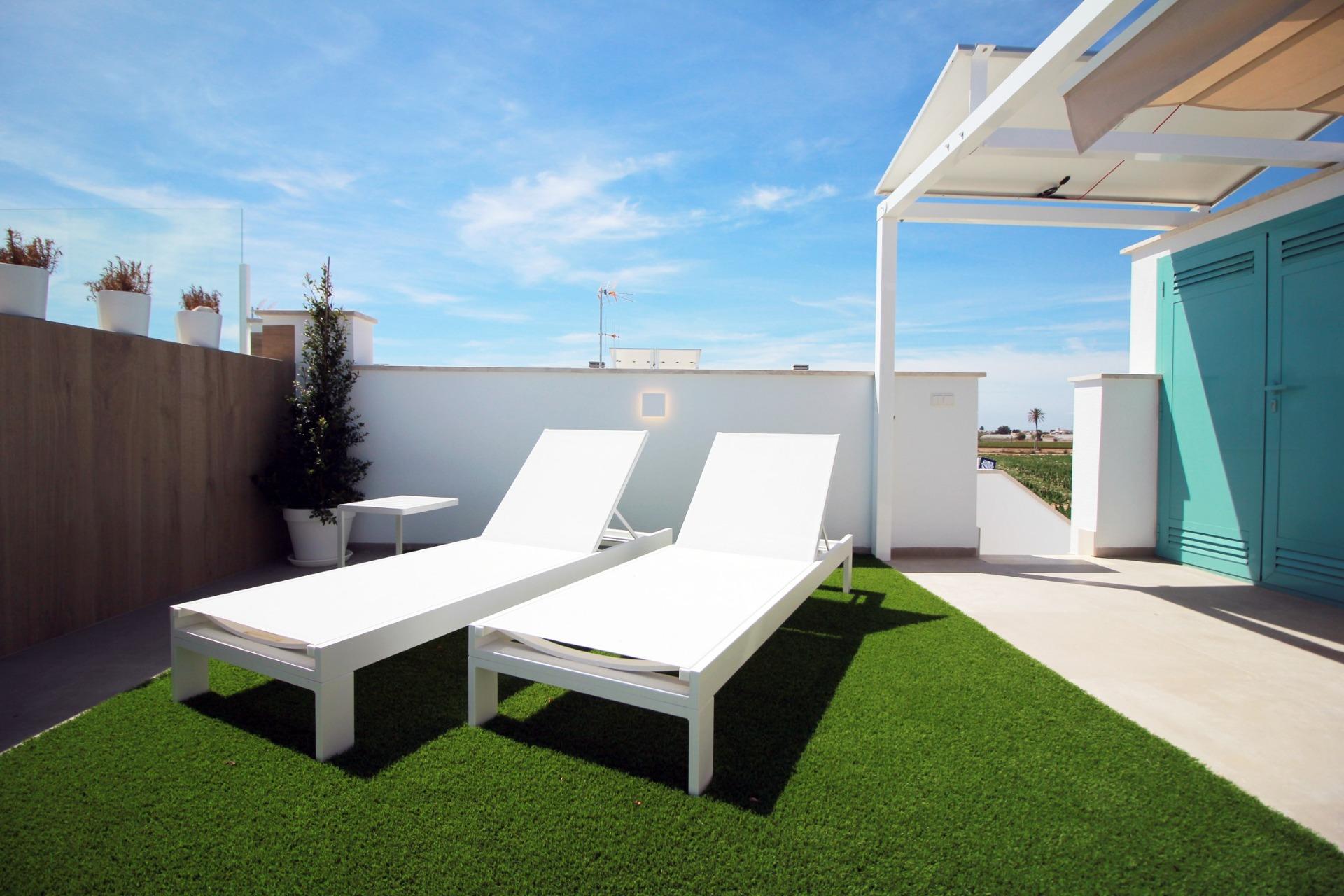 NEW-BUILD-RESIDENTIAL-COMPLEX-IN-TORRE-DE-LA-HORADADA-26 Sun-drenched solarium with sleek white loungers and modern pergola on top floor 3-bedroom apartment in Torre de la Horadada.