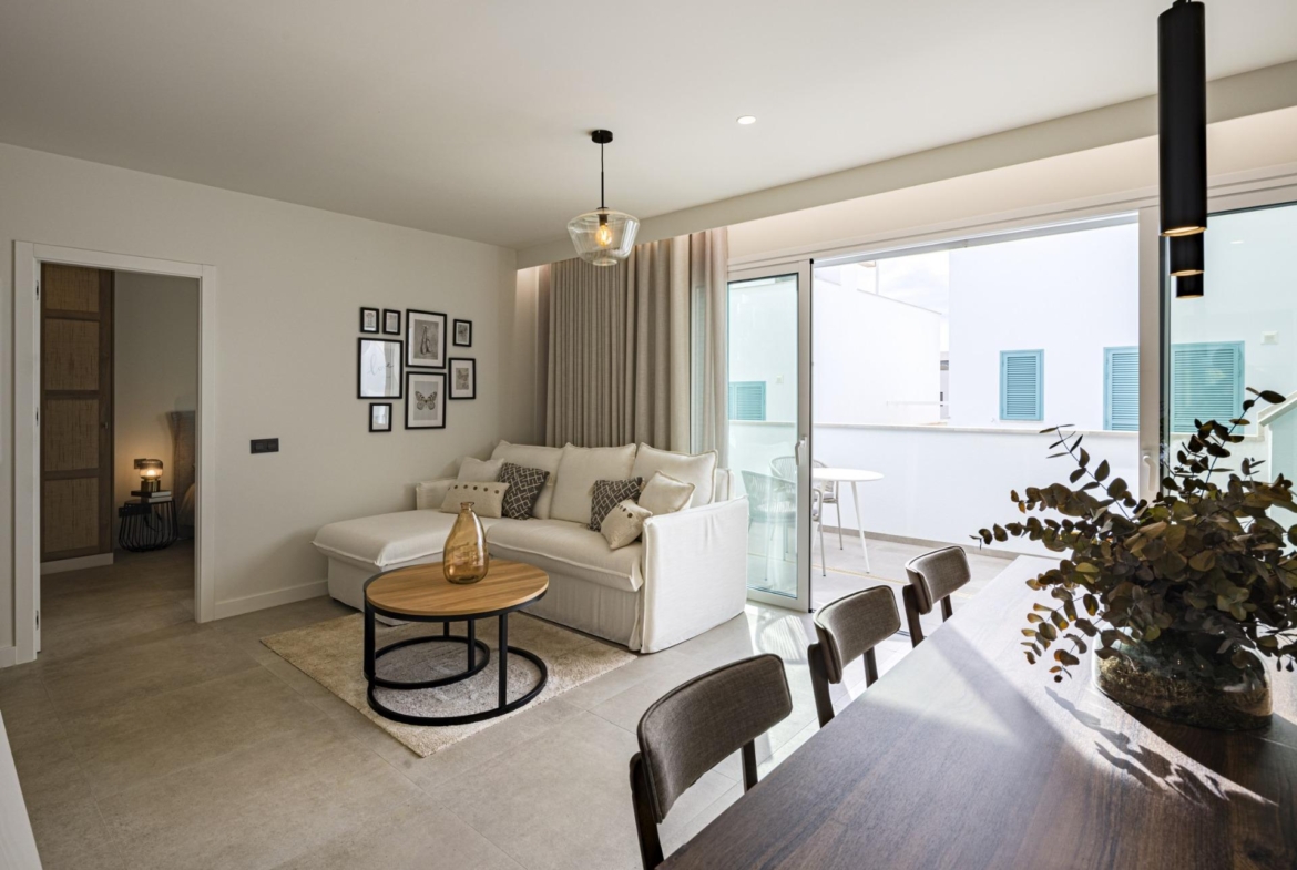 NEW-BUILD-RESIDENTIAL-COMPLEX-IN-TORRE-DE-LA-HORADADA-28 Bright modern living room with elegant sofa and dining area opening onto private terrace in Torre de la Horadada top floor apartment
