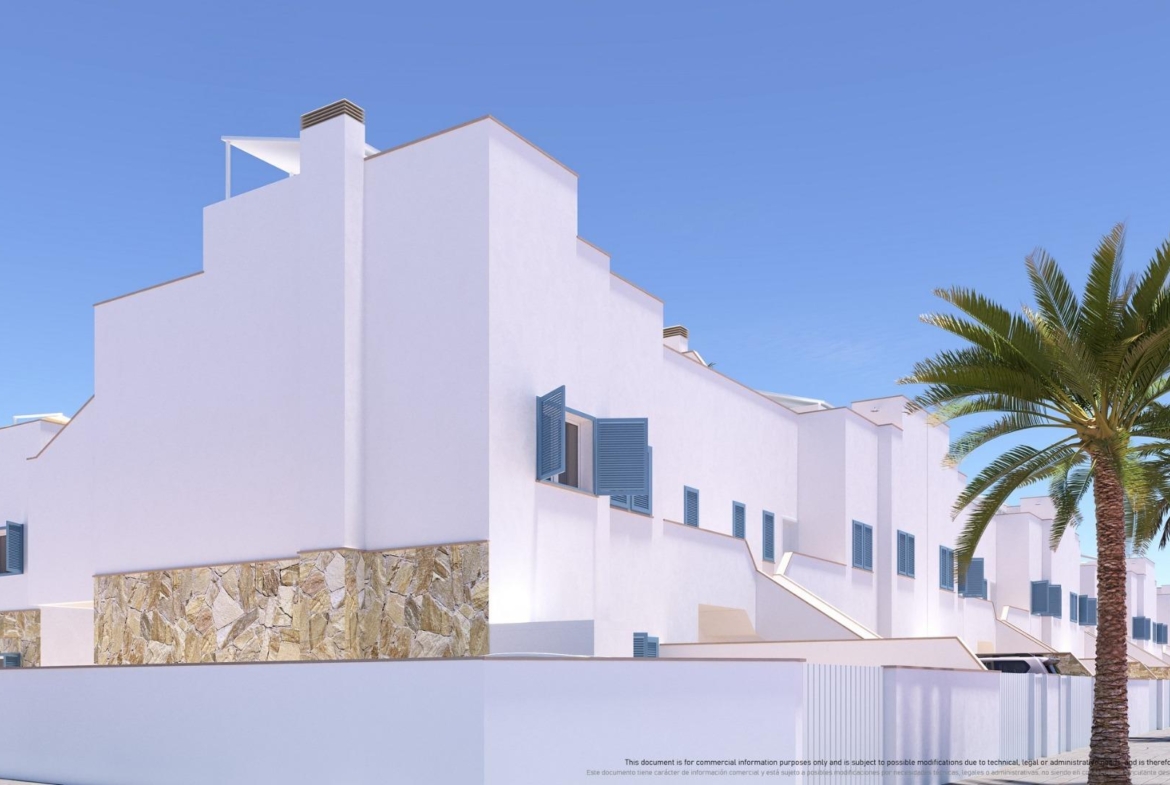 NEW-BUILD-RESIDENTIAL-COMPLEX-IN-TORRE-DE-LA-HORADADA-3 Modern whitewashed top floor apartment in Torre de la Horadada with blue shutters, stone accents, and lush palm trees under clear sky.