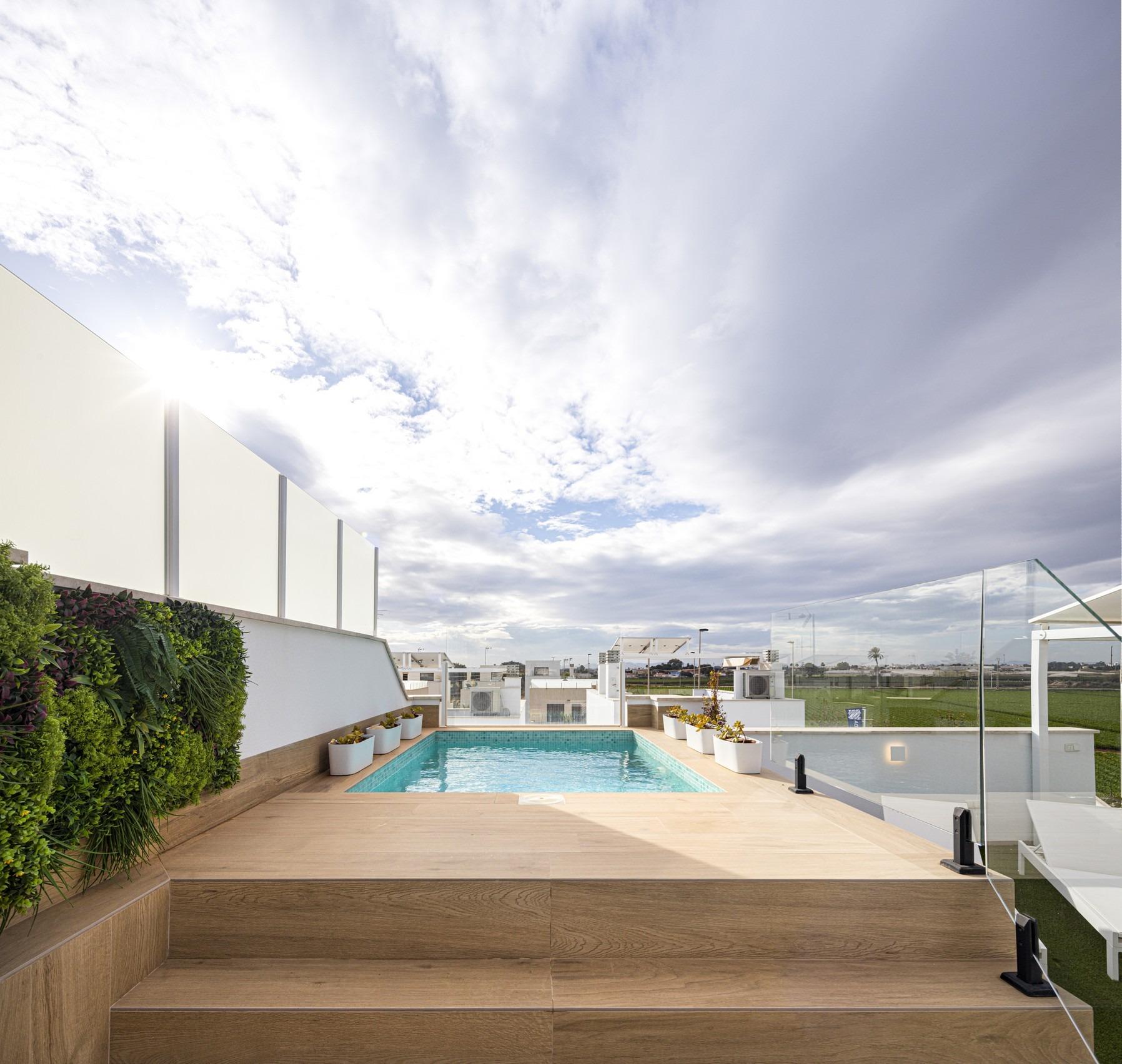 NEW-BUILD-RESIDENTIAL-COMPLEX-IN-TORRE-DE-LA-HORADADA-30 Sun-drenched private pool with sleek glass balustrades and lush greenery on the solarium of a new build 3-bedroom apartment in Torre de la Horadada.