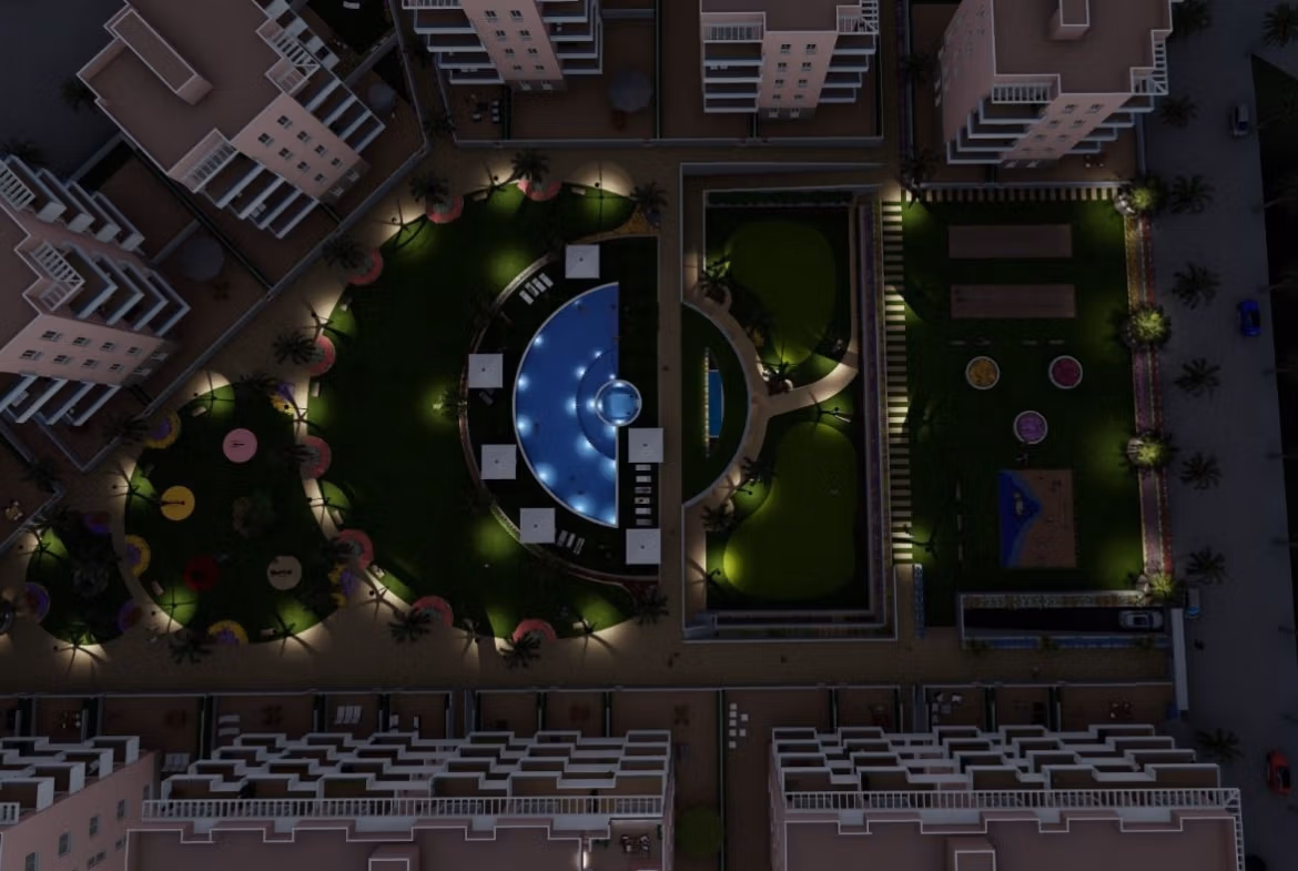 Night view of a modern, landscaped communal garden with pool and playground surrounding new build 3-bedroom ground floor apartments in El Raso, Guardamar del Segura.