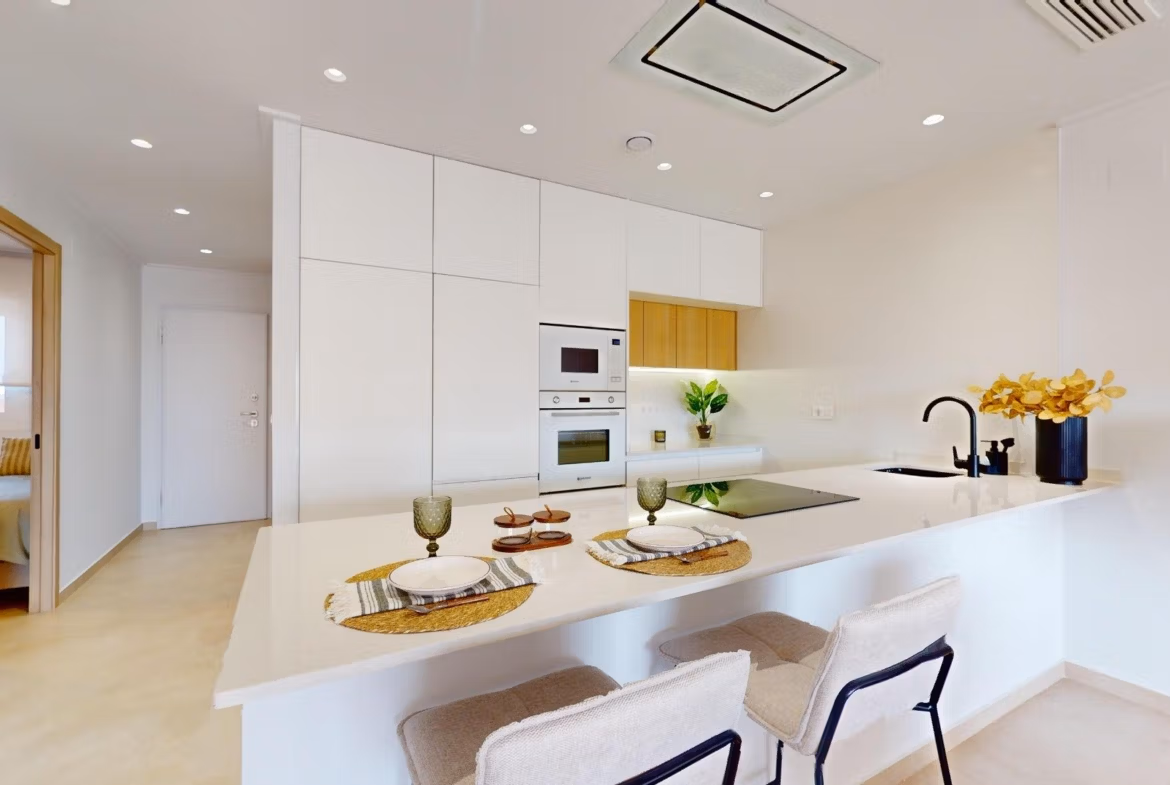 Modern open-plan kitchen with sleek white cabinetry and breakfast bar in luminous 3-bedroom penthouse, El Raso, Guardamar del Segura