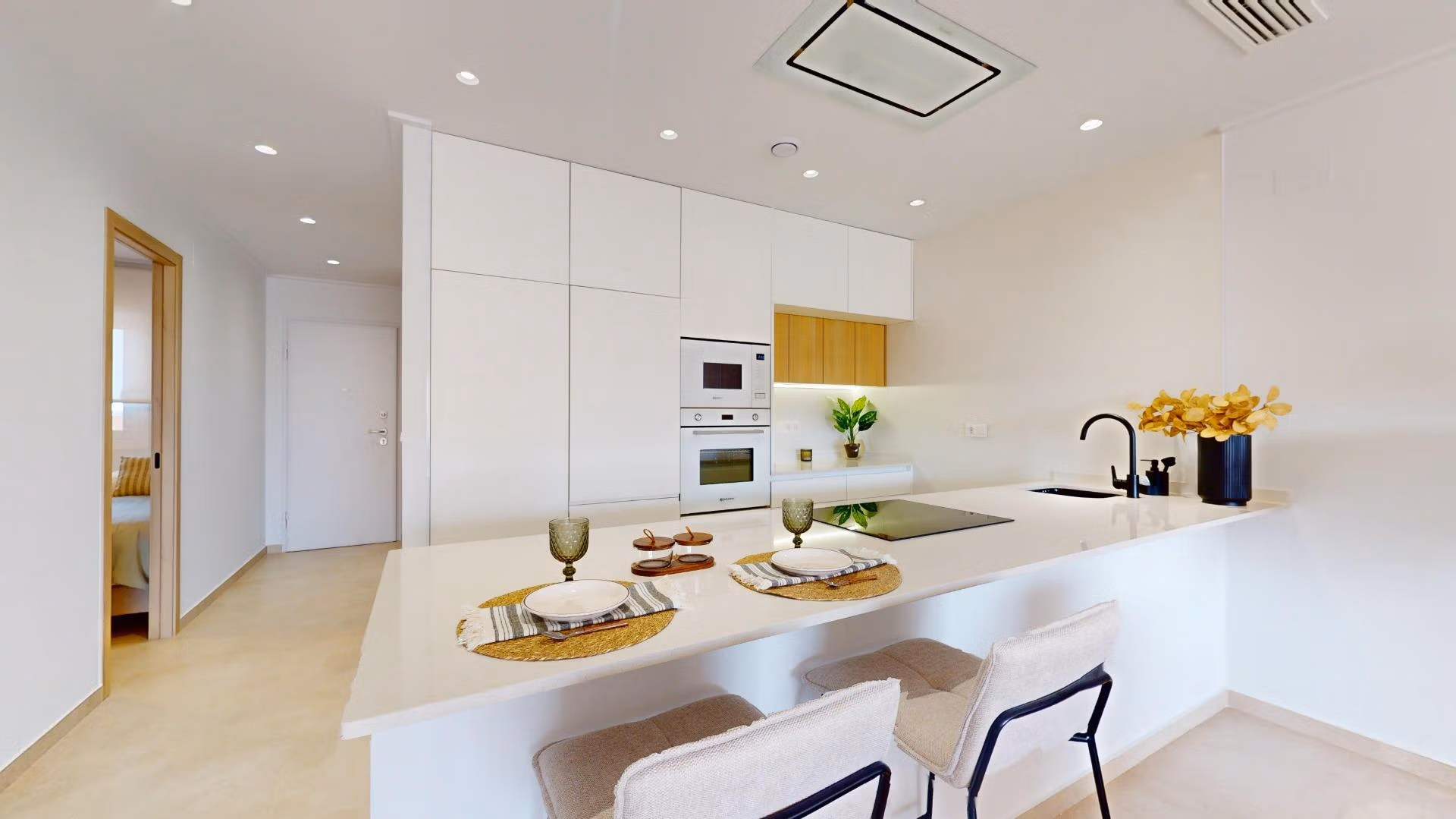 Modern open-plan kitchen with sleek white cabinetry and breakfast bar in luminous 3-bedroom penthouse, El Raso, Guardamar del Segura