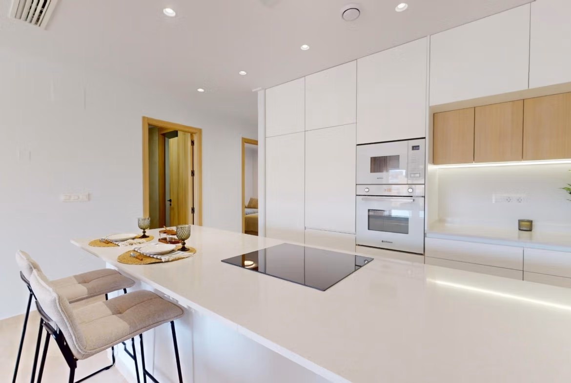Bright modern kitchen with sleek white cabinetry and breakfast bar in luxury 3-bedroom penthouse in El Raso, Guardamar del Segura