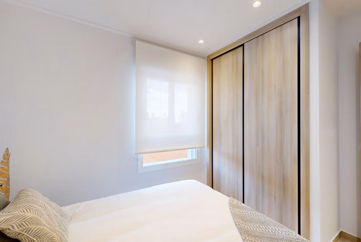 Bright, modern 3-bedroom ground floor apartment bedroom with sleek wooden wardrobe in El Raso, Guardamar del Segura.