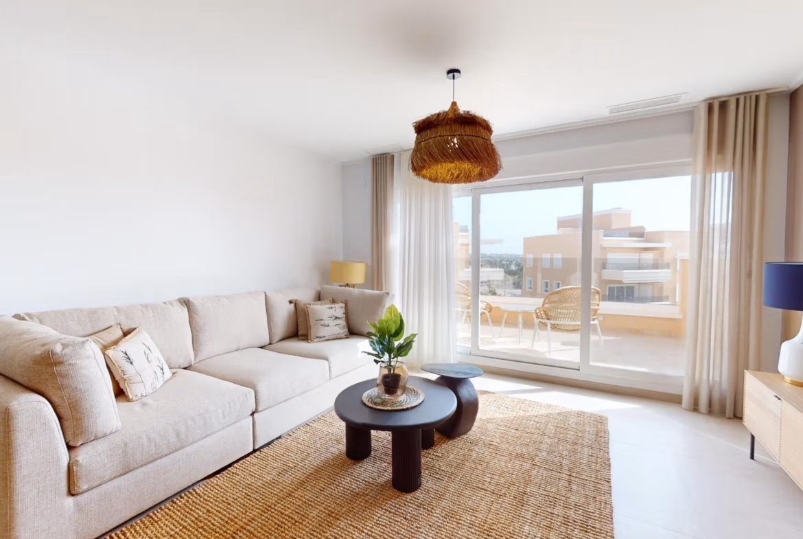 Bright, modern living room with elegant beige sofa and sunlit terrace in 3-bedroom penthouse with solarium, El Raso, Guardamar del Segura.