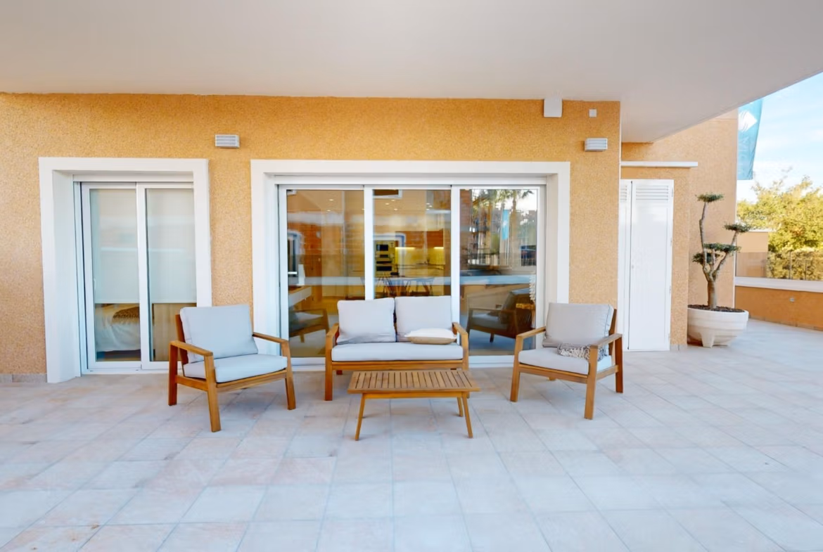 Spacious sun-drenched terrace with modern outdoor seating of a 3-bedroom ground floor apartment in El Raso, Guardamar del Segura.