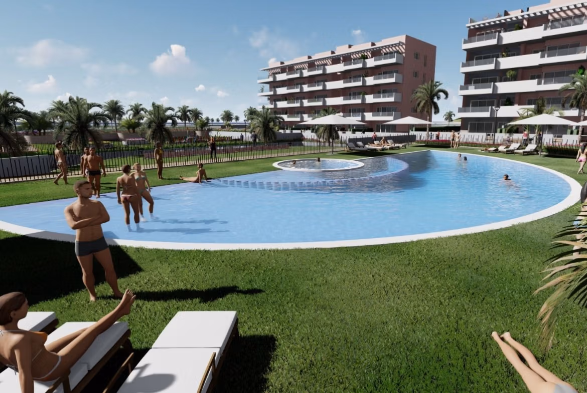 Stunning communal infinity pool with sunbathers and landscaped gardens at luminous 3-bedroom penthouse in El Raso, Guardamar del Segura.