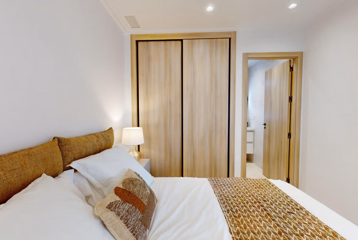 Bright modern bedroom with elegant wood wardrobe in 3-bedroom ground floor apartment in El Raso, Guardamar del Segura.