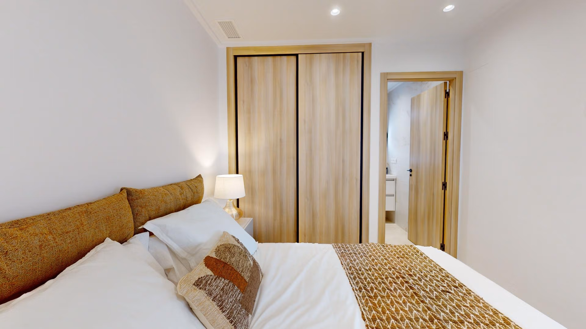 Bright modern bedroom with elegant wood wardrobe in 3-bedroom ground floor apartment in El Raso, Guardamar del Segura.