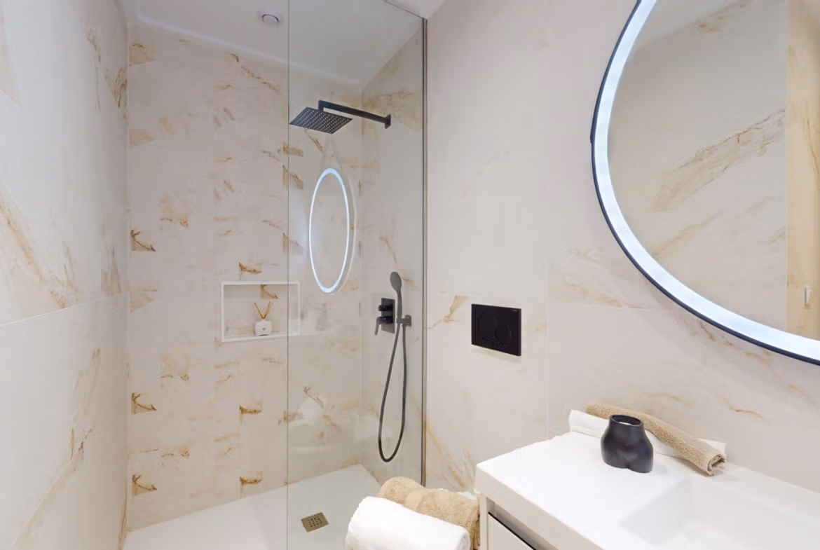 Bright modern bathroom with rain shower and illuminated round mirror in new build 3-bedroom apartment, El Raso, Guardamar del Segura