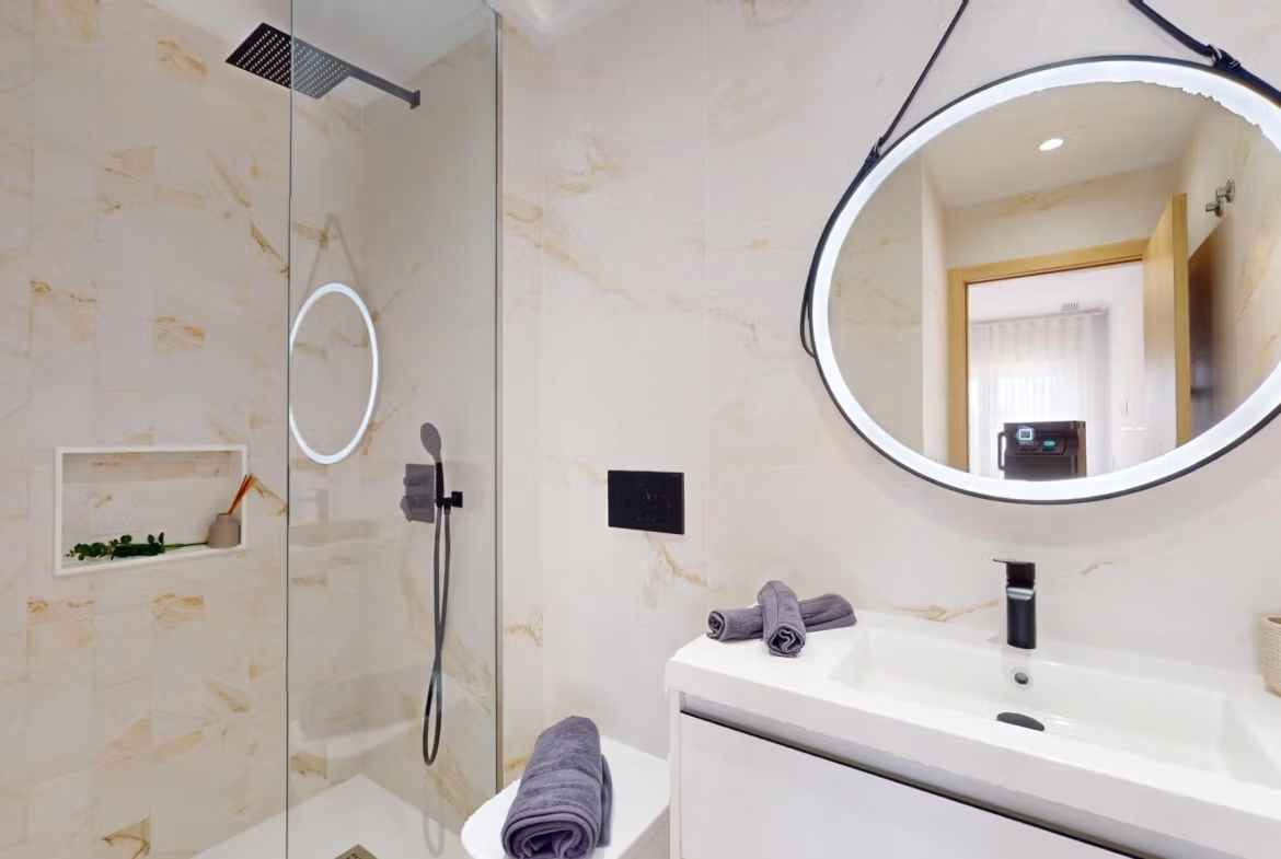 Modern, elegant bathroom with illuminated round mirror in luminous 3-bedroom penthouse with solarium in El Raso, Guardamar del Segura
