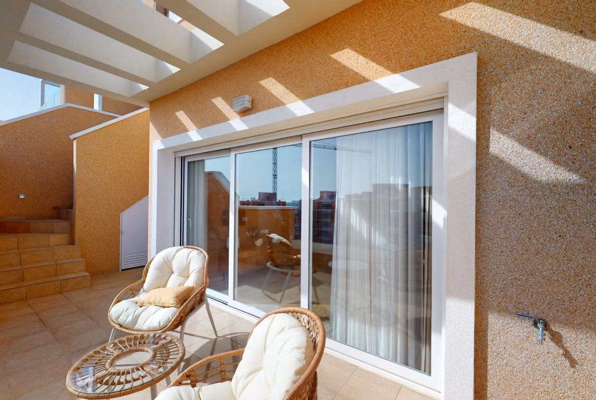 Sunlit private terrace with wicker seating at luminous 3-bedroom penthouse in El Raso, Guardamar del Segura.