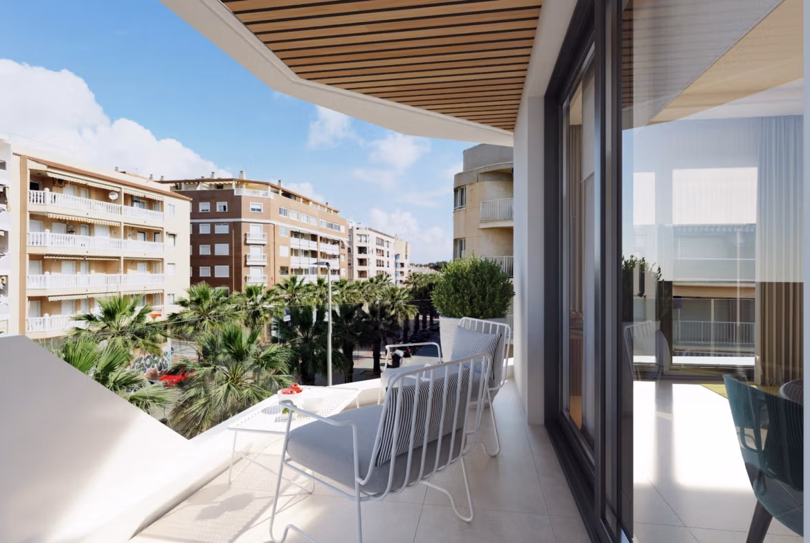 NEW-BUILD-RESIDENTIAL-IN-GUARDAMAR-DEL-SEGURA-11 Bright, modern balcony with sleek seating overlooking palm trees and elegant buildings in a 2-bedroom apartment near Guardamar del Segura beach.