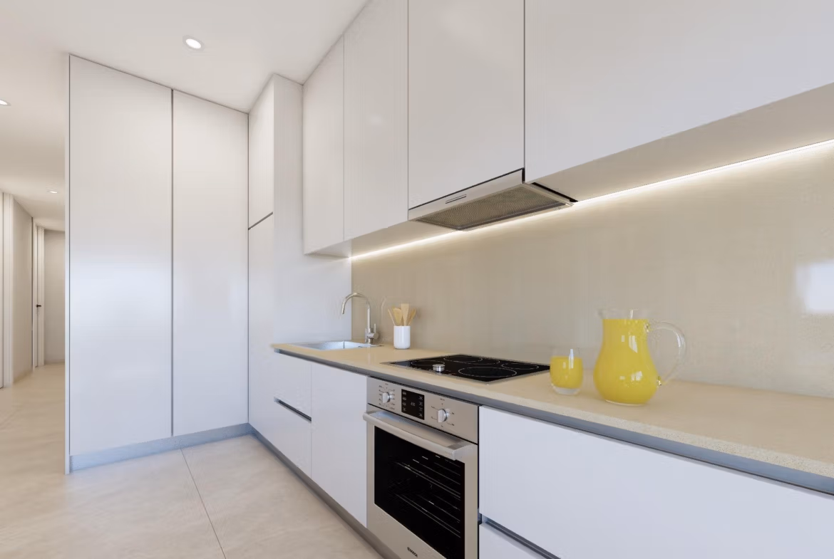 NEW-BUILD-RESIDENTIAL-IN-GUARDAMAR-DEL-SEGURA-6 Bright modern kitchen with sleek white cabinetry in a luxury 2-bedroom apartment near Guardamar del Segura beach.