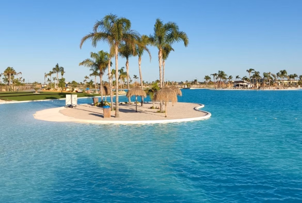 Stunning sun-drenched lakefront view with palm-fringed lagoon at Santa Rosalía Lake and Life Resort penthouse for sale
