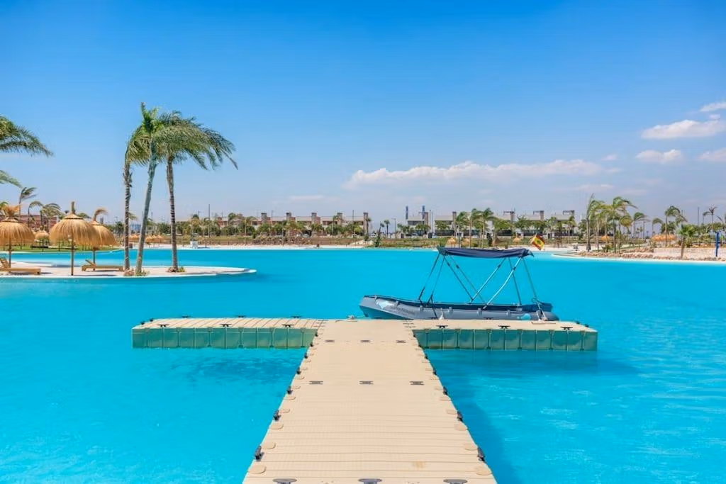 Stunning turquoise lagoon with palm trees and floating dock near the impressive 3-bedroom penthouse in Santa Rosalía Lake and Life Resort