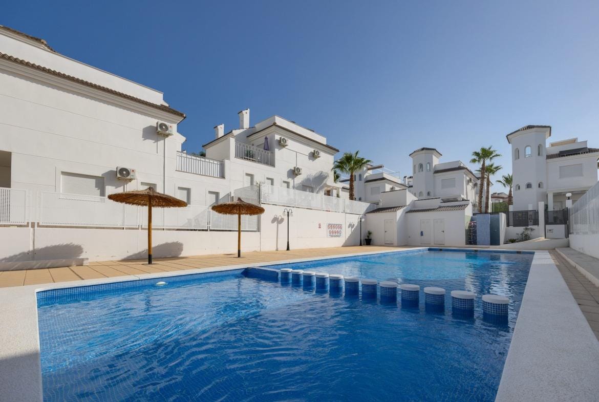 Bright, modern 3-bedroom villa in El Oasis, San Fulgencio featuring a private sparkling pool and sun-drenched terrace with umbrellas.