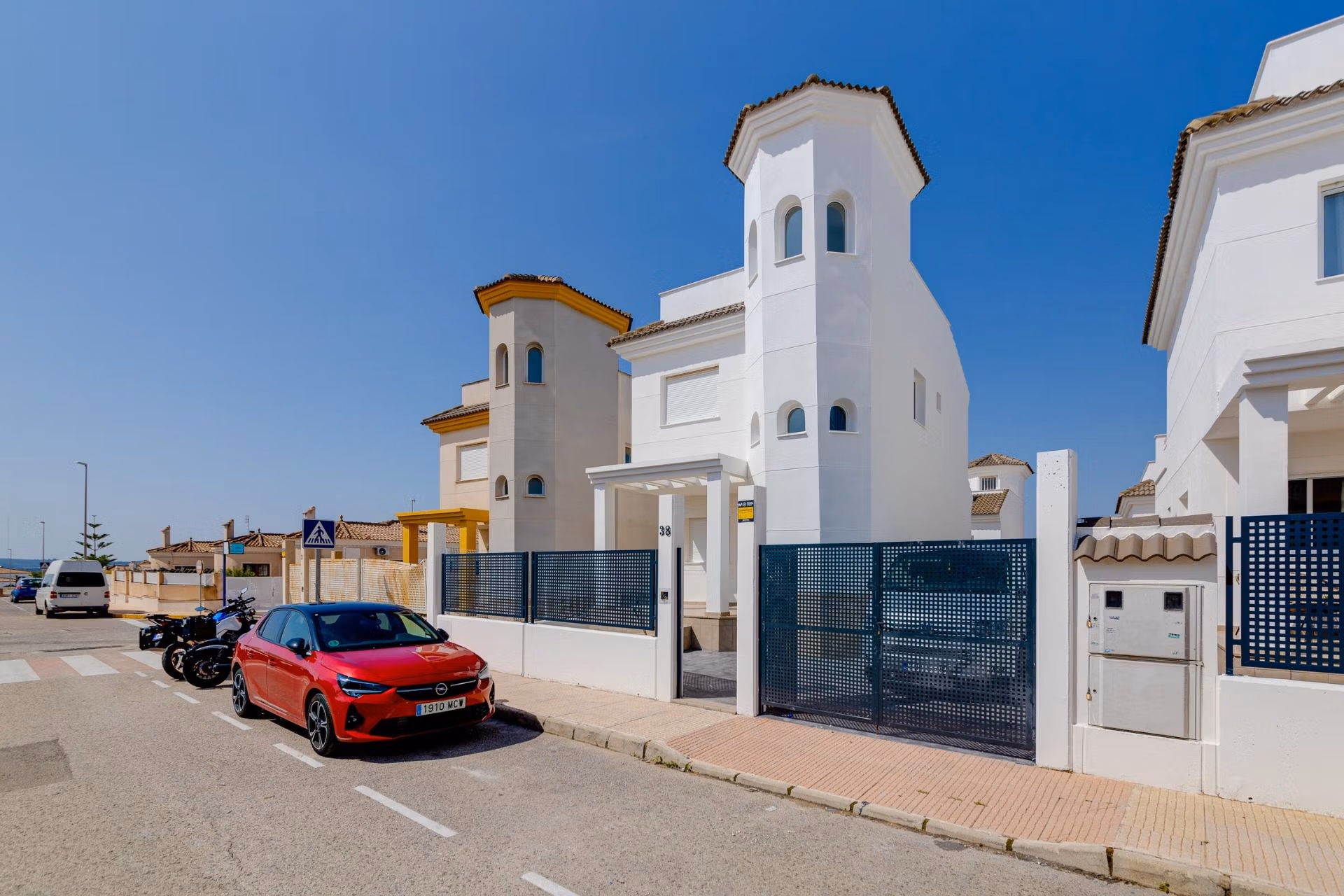 NEW-BUILD-RESIDENTIAL-IN-SAN-FULGENCIO-1 Modern, sun-drenched 2 bedroom semi-detached villa with distinctive tower facade in El Oasis La Marina Urbanisation, featuring secure gated entrance.
