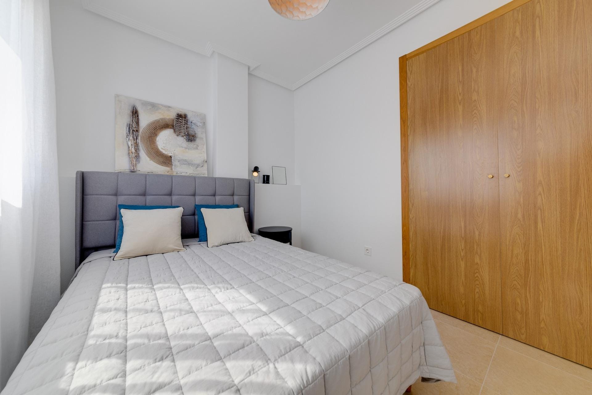NEW-BUILD-RESIDENTIAL-IN-SAN-FULGENCIO-16 Bright, cozy bedroom with modern decor and built-in wooden wardrobe in a 3-bedroom villa in El Oasis, San Fulgencio.