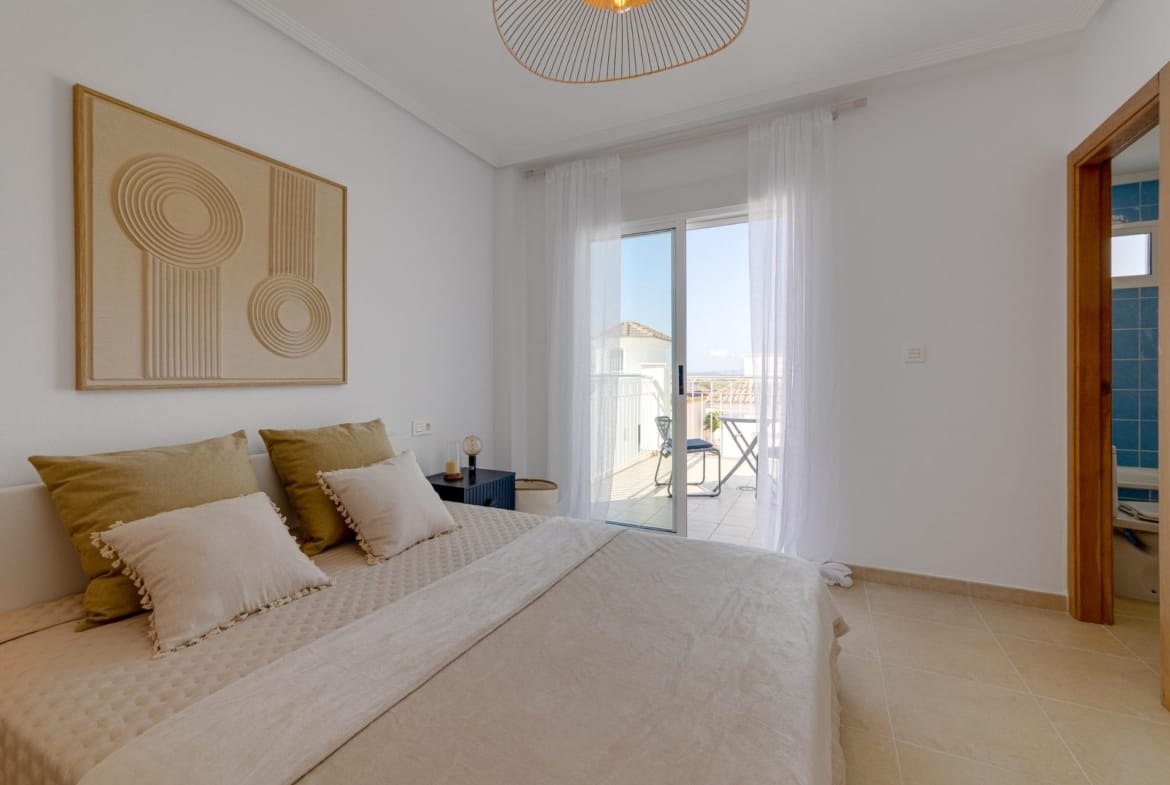 Bright elegant bedroom with soft neutral tones and balcony access in a 3-bedroom villa with solarium, El Oasis, San Fulgencio.
