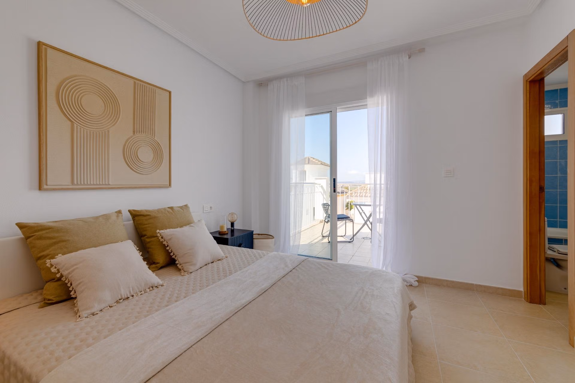 NEW-BUILD-RESIDENTIAL-IN-SAN-FULGENCIO-19 Bright elegant bedroom with soft neutral tones and balcony access in a 3-bedroom villa with solarium, El Oasis, San Fulgencio.