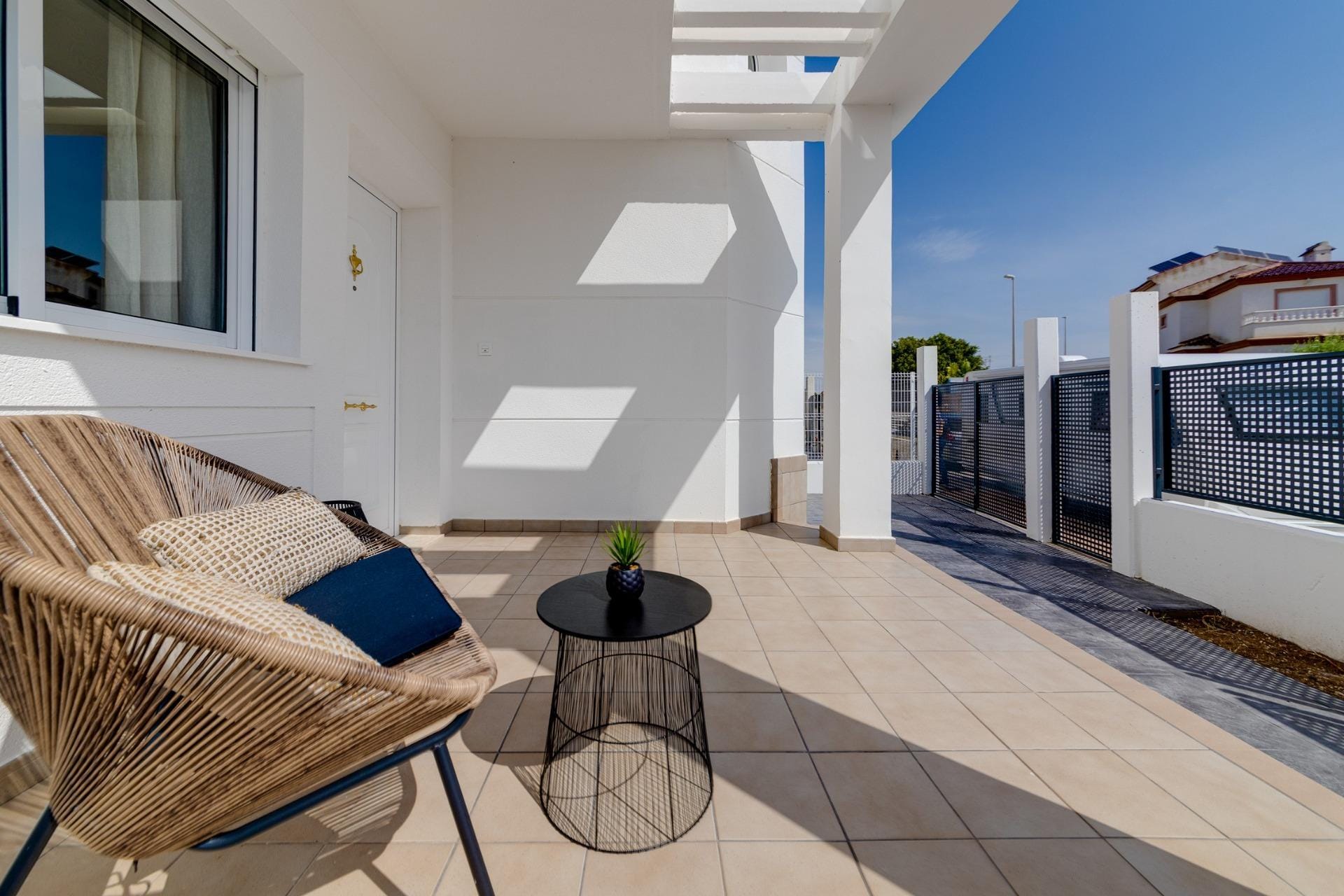 NEW-BUILD-RESIDENTIAL-IN-SAN-FULGENCIO-23 Sun-drenched terrace with modern wicker chair and sleek table at key ready 3 bedroom villa in El Oasis, San Fulgencio