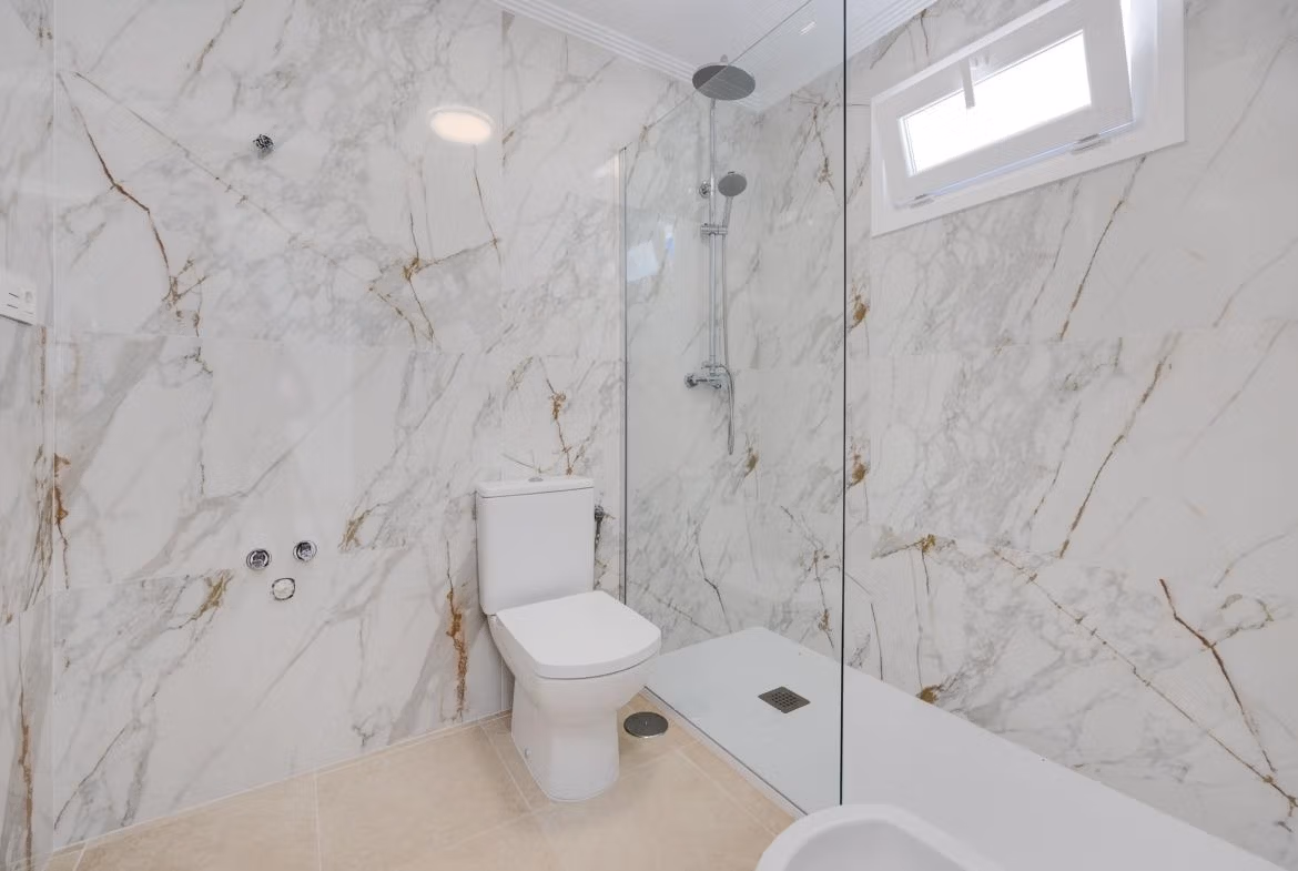 NEW-BUILD-RESIDENTIAL-IN-SAN-FULGENCIO-25 Bright modern bathroom with marble walls and walk-in shower in 2 bedroom semi-detached villa in El Oasis La Marina Urbanisation