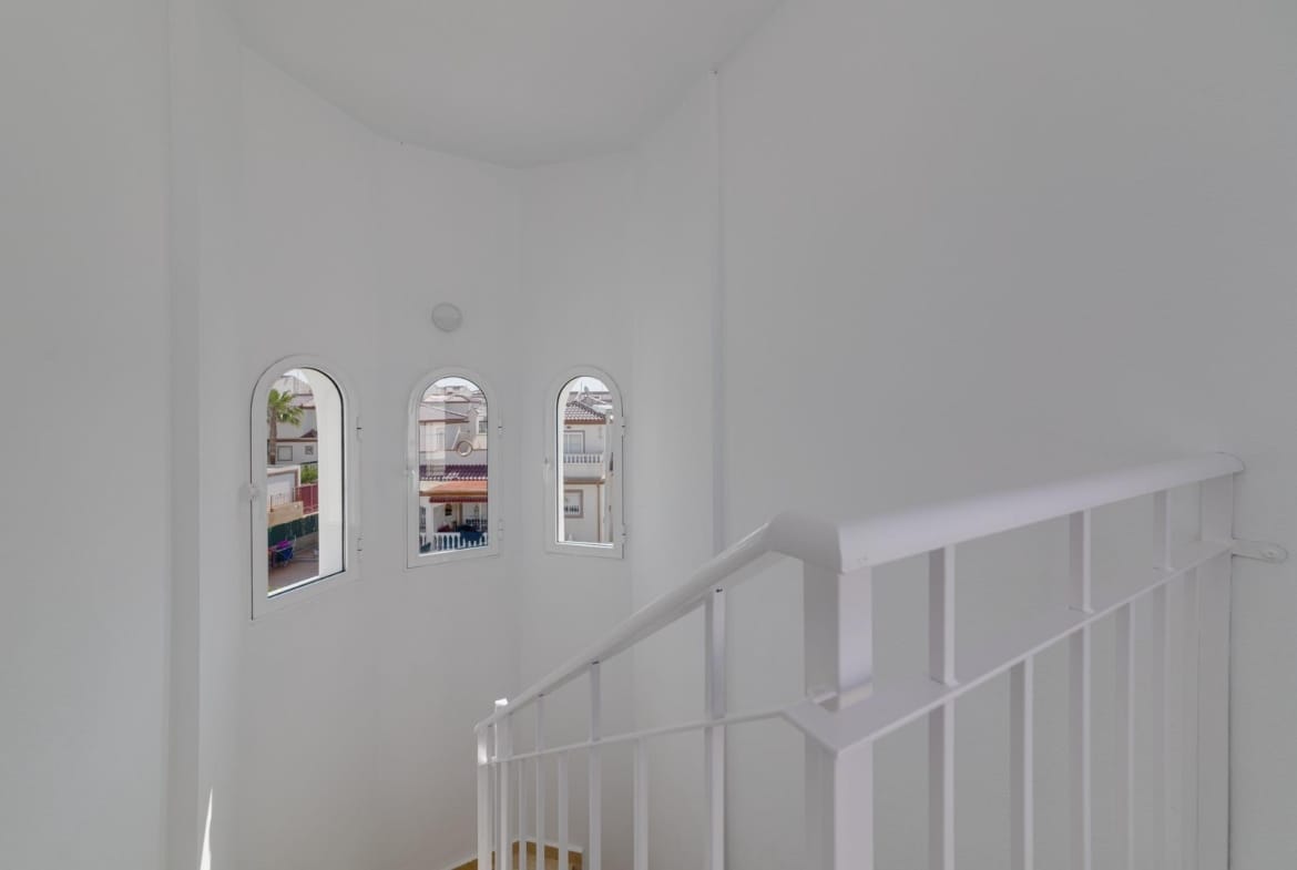 Bright airy staircase with elegant arched windows in a modern 3-bedroom villa at El Oasis, San Fulgencio.