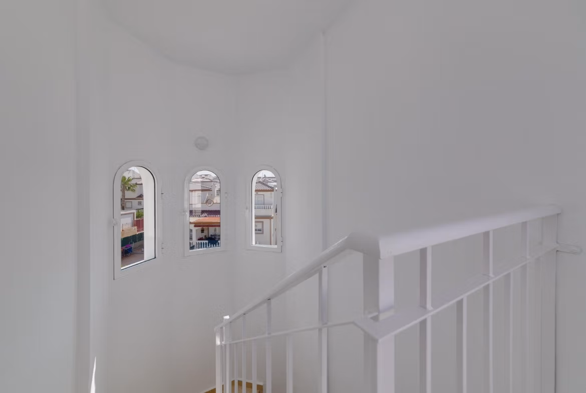 Bright airy staircase with elegant arched windows in a modern 3-bedroom villa at El Oasis, San Fulgencio.