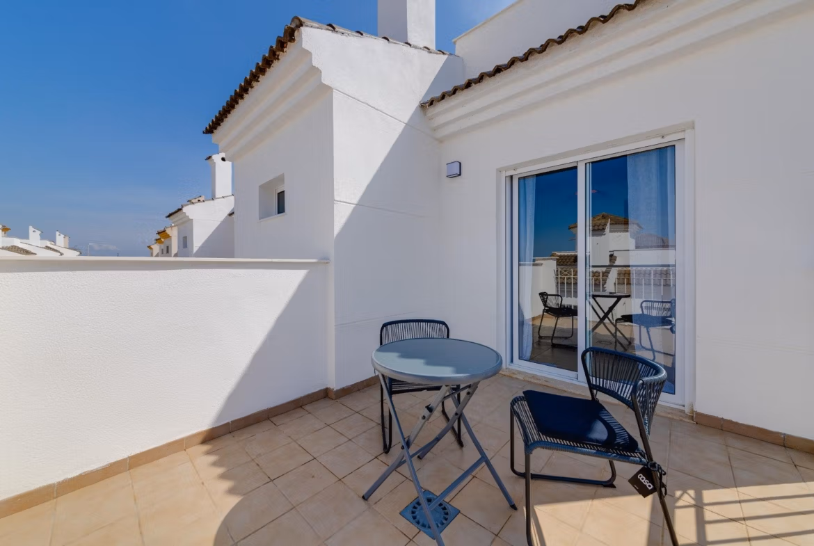 NEW-BUILD-RESIDENTIAL-IN-SAN-FULGENCIO-30 Sun-drenched private terrace with modern seating at a 2-bedroom semi-detached villa in El Oasis La Marina Urbanisation.