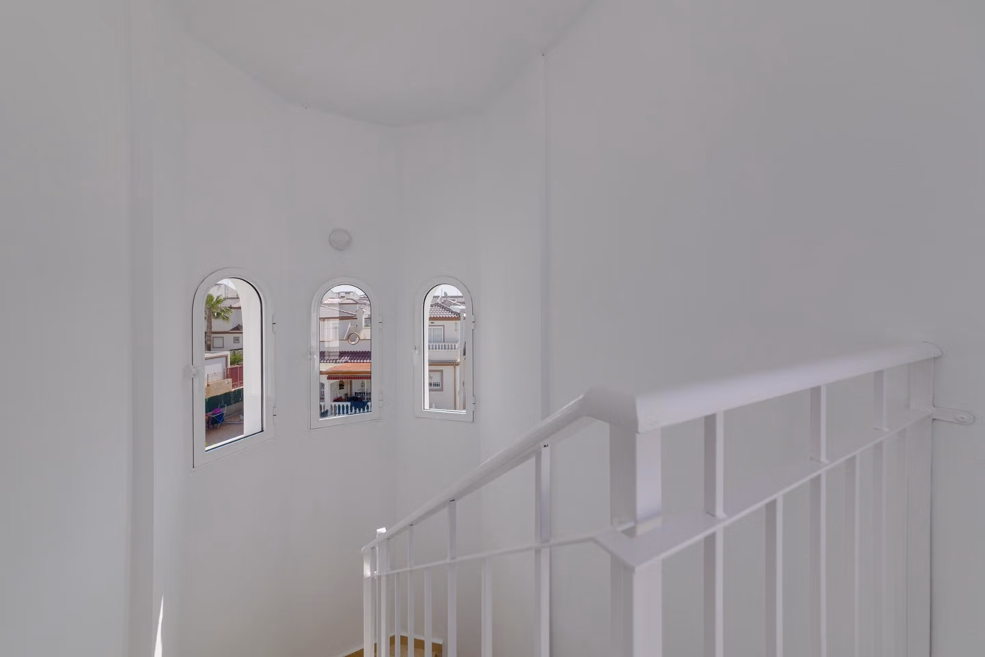 NEW-BUILD-RESIDENTIAL-IN-SAN-FULGENCIO-31 Bright airy staircase with elegant arched windows in a key ready 2-bedroom semi-detached villa at El Oasis La Marina.
